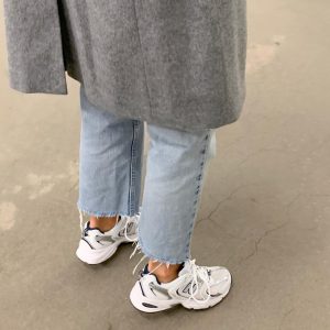zapatillas blancas de deporte con vaqueros
