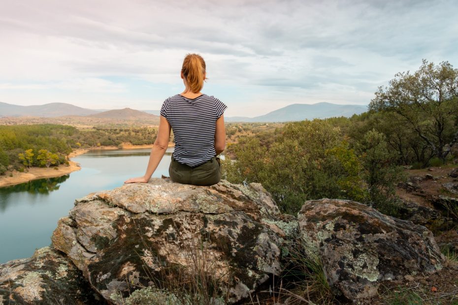 Mujer mirando un pantano en la sierra de madrid